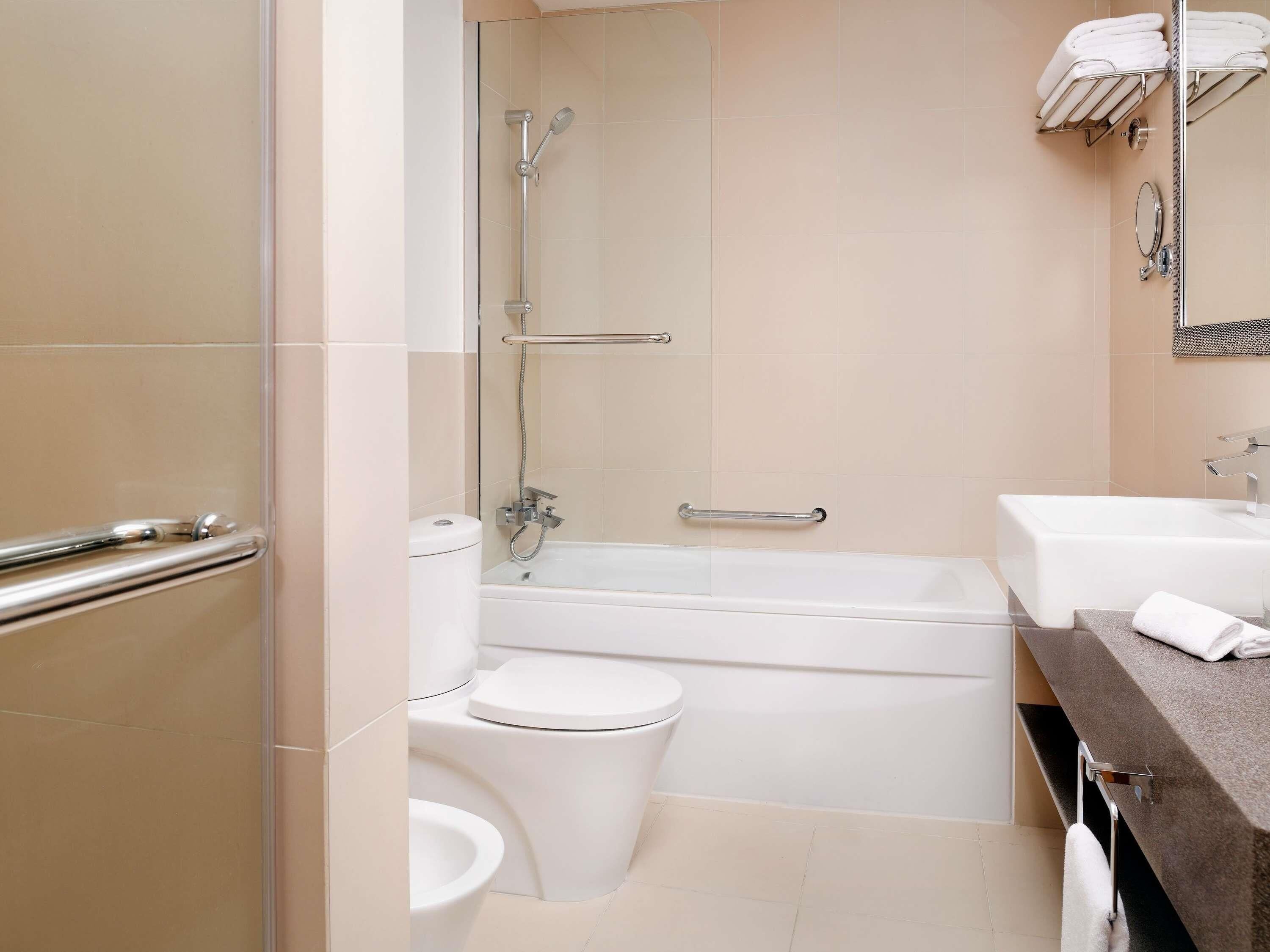 A bathroom with a bathtub, toilet, and sink.
