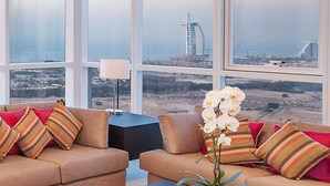 A high-rise room with a large window overlooking a cityscape, including a distinctive building.