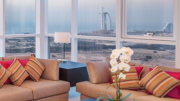 Habitación en un edificio alto con un ventanal grande que da a una vista panorámica de la ciudad, incluyendo un edificio emblemático.