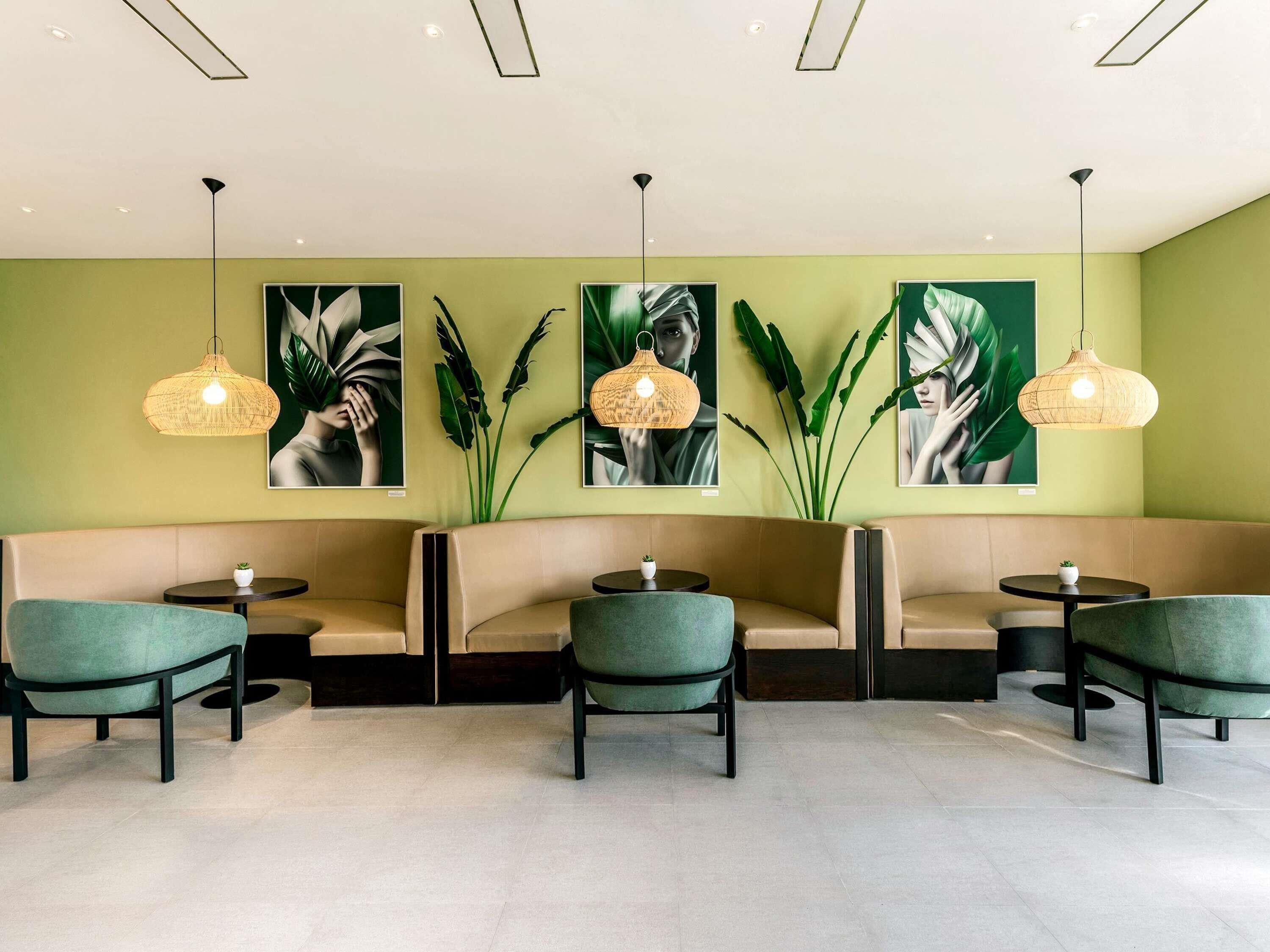 A modern lounge area with a sofa, chairs, and pendant lights.