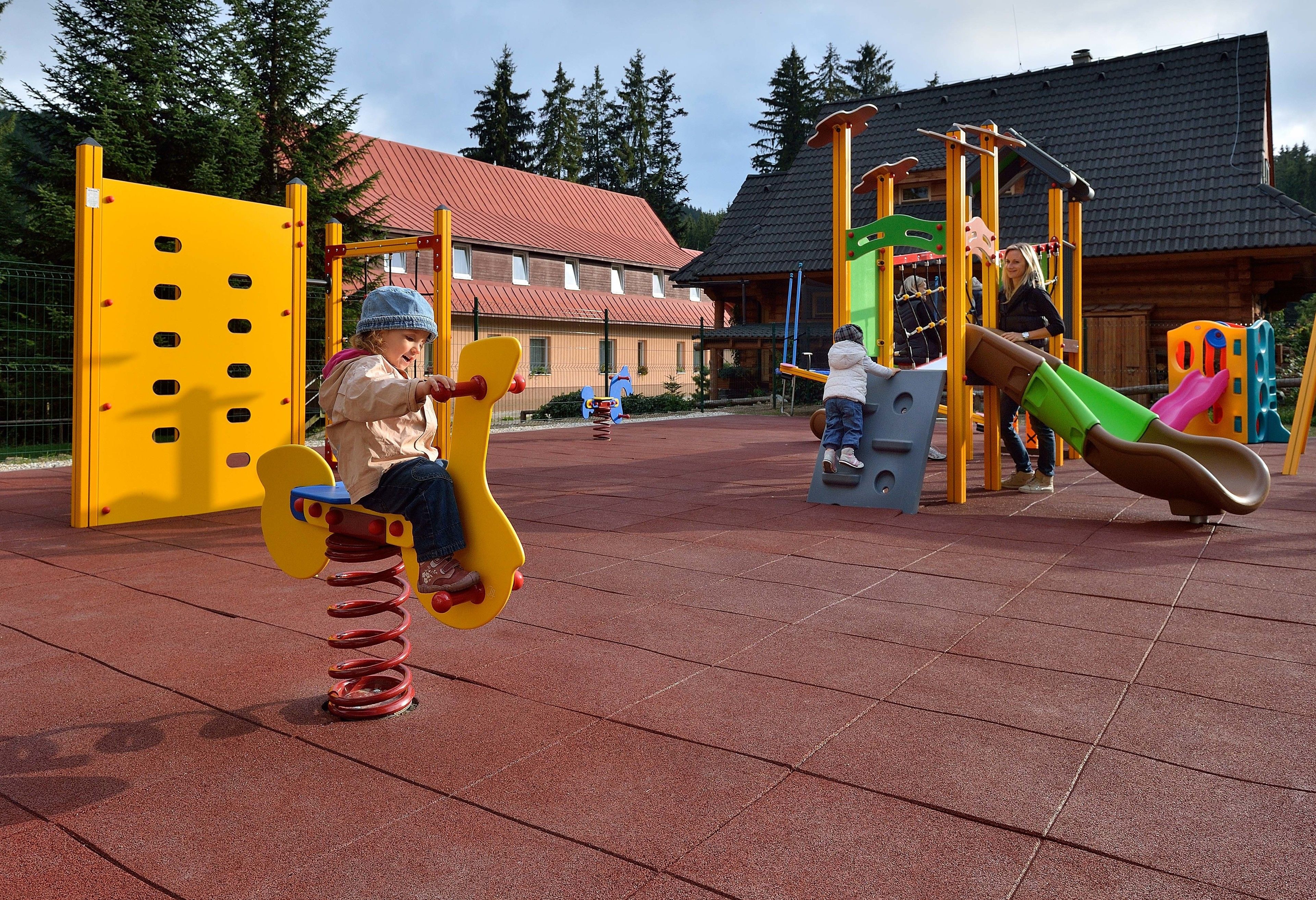 Un parque infantil con diversas estructuras de juego, incluyendo un sube y baja y un tobogán.