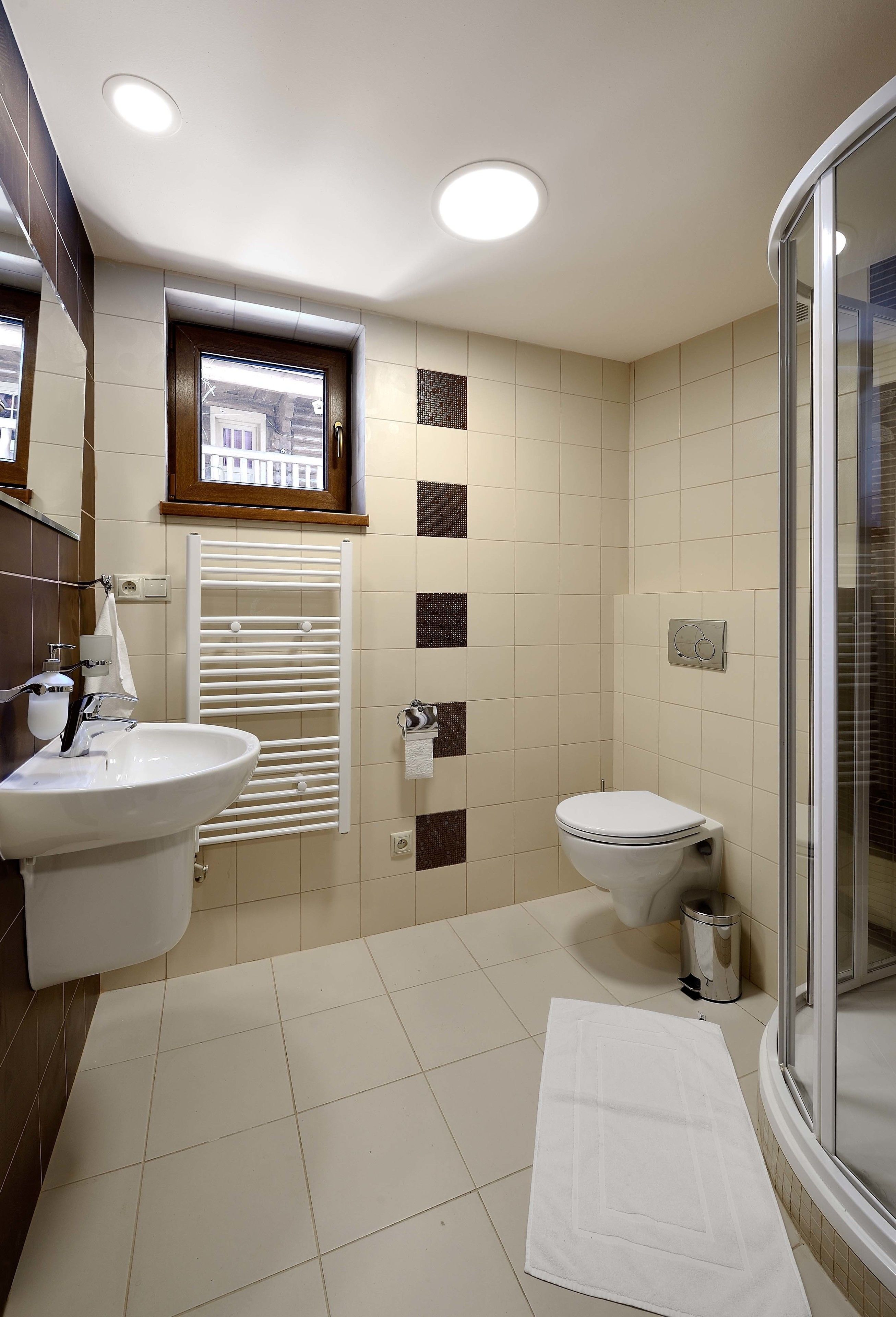 Un baño moderno con lavamanos, inodoro y ducha.