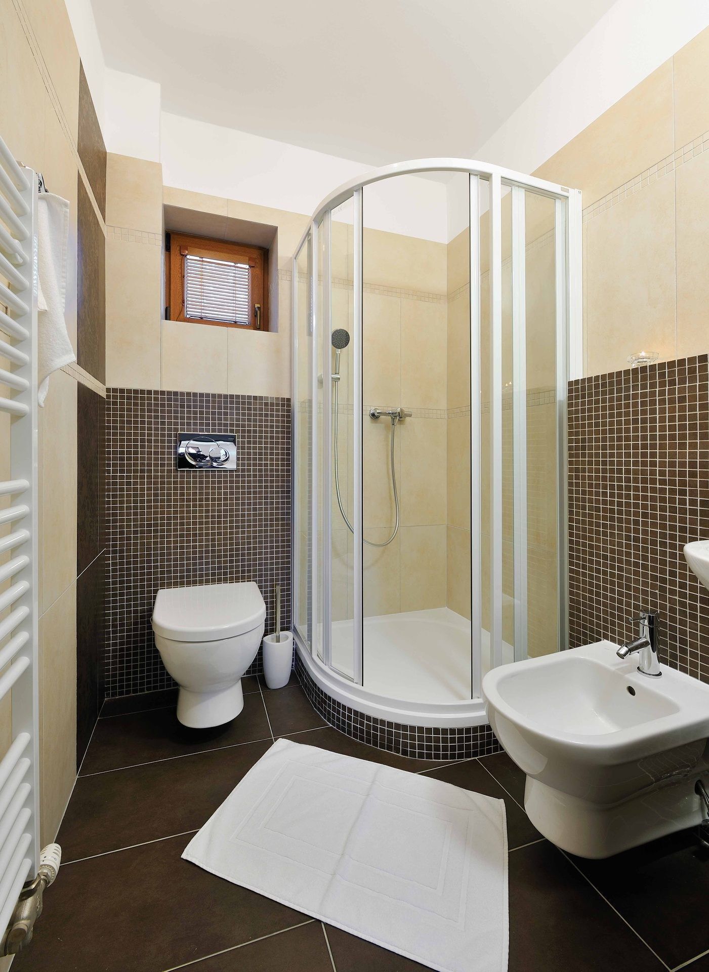 A bathroom with a glass-enclosed shower, a toilet, a bidet, and a sink.
