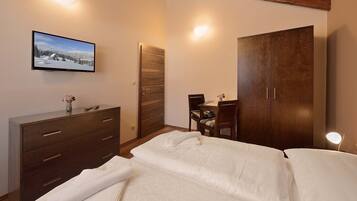 A bedroom with a bed, a dresser, a desk with a chair, and a wardrobe.