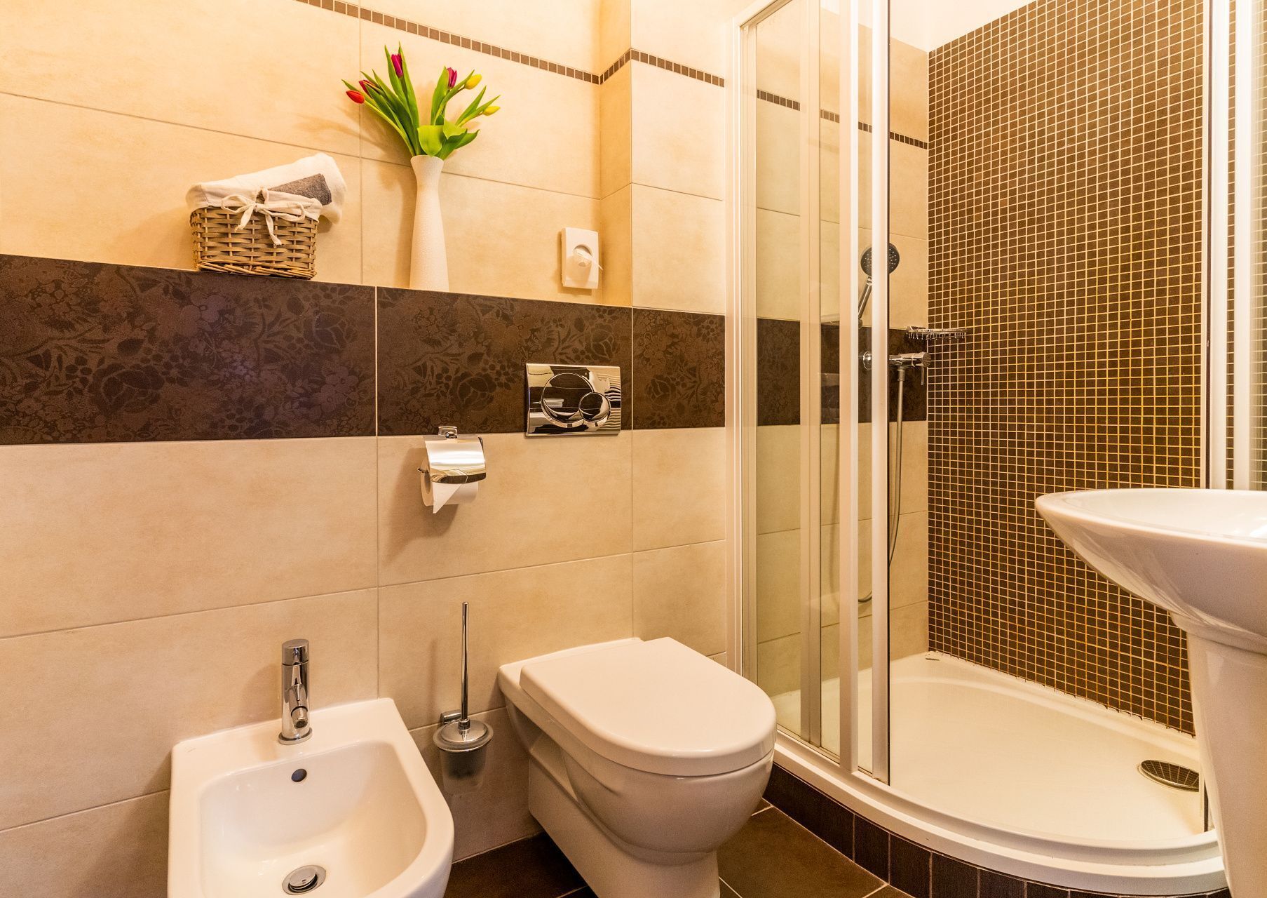 Une salle de bain équipée d’un bidet, de toilettes et d’un lavabo.