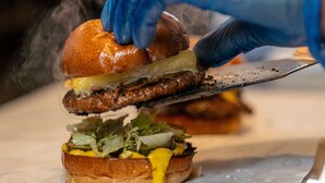 A close-up of a sandwich being cut with a knife. - PubLove @ The Crown, Battersea - Hostel (London)