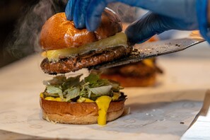 A close-up of a sandwich being cut with a knife. - PubLove @ The Crown, Battersea - Hostel (London)