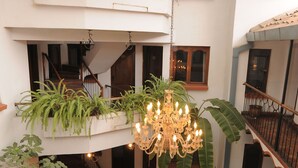 Un patio de varios niveles con una escalera, plantas en macetas y un candelabro.