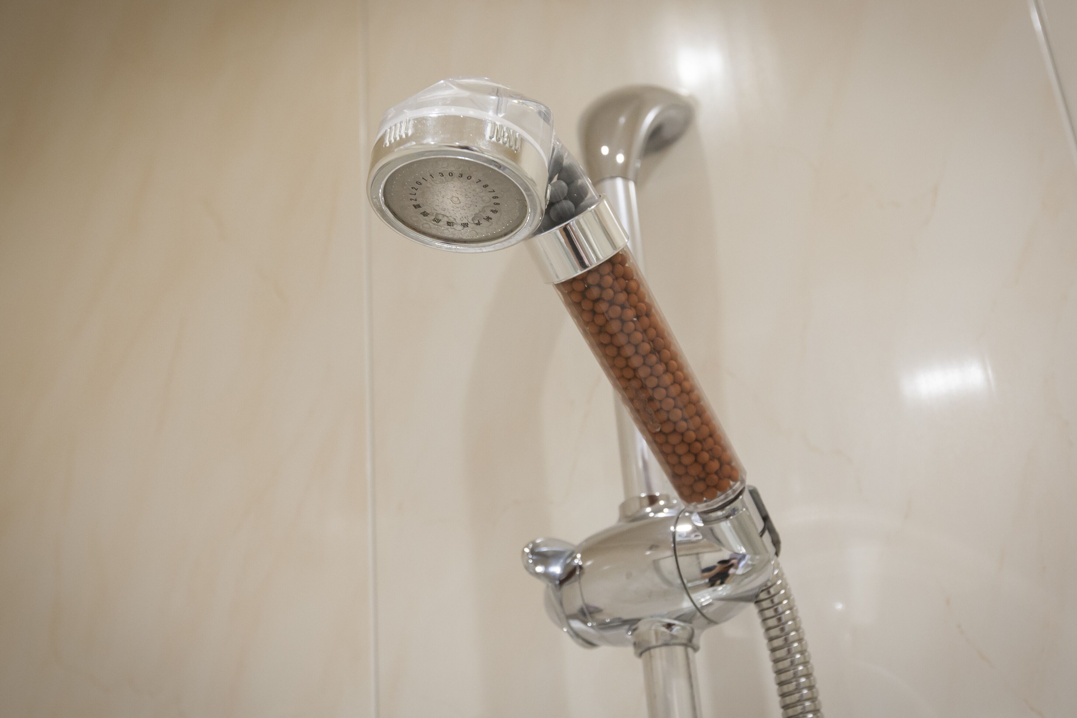 A shower with a clear glass enclosure and a wooden handle.