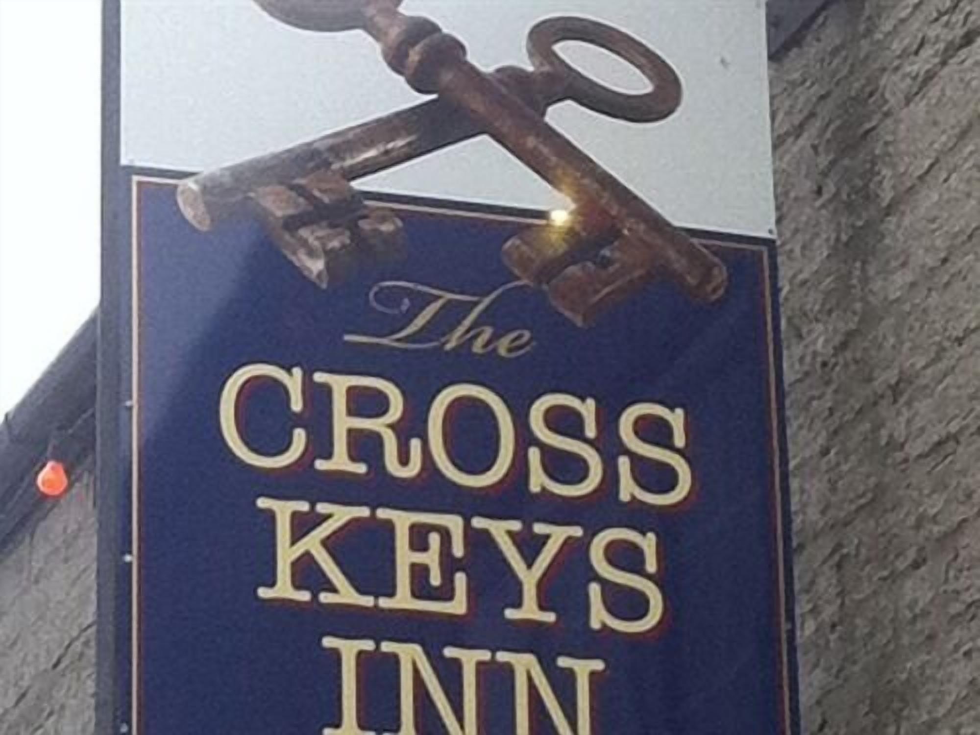 A sign for The Cross Keys Inn, featuring a prominent key symbol.