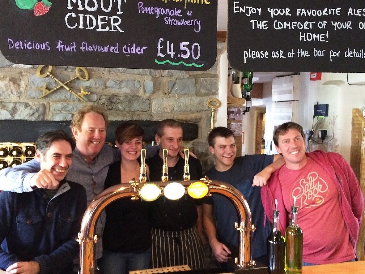 A group of people standing in front of a tap labeled "MOUT CIDER" with a price of £4.50.