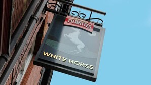 Placa do pub 'White Horse' com silhueta de cavalo e o texto 'Cervejeiros desde 1807'.