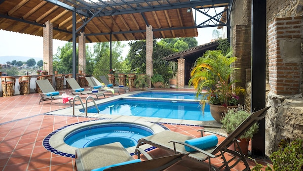 Un área de piscina con sillas de descanso y un jacuzzi.