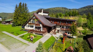 Un chalet de dos pisos con balcón, un telesilla y un parque infantil.
