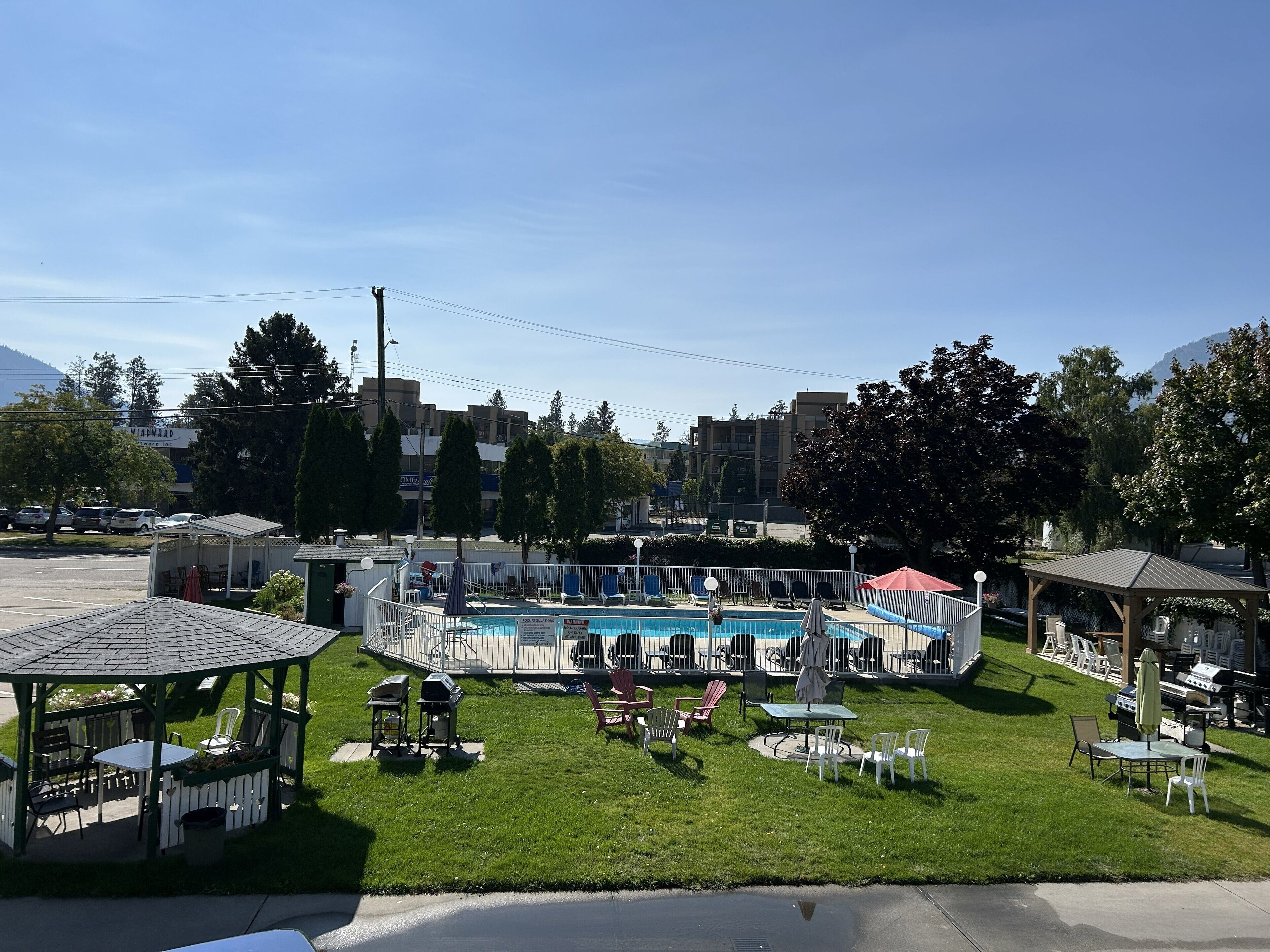 Un área de piscina con sillas de descanso y un pabellón.