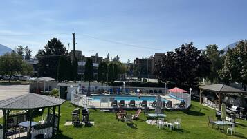 Un área de piscina con sillas de descanso y un pabellón.