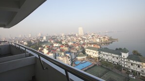 A high-rise building with a view of a cityscape and a body of water.