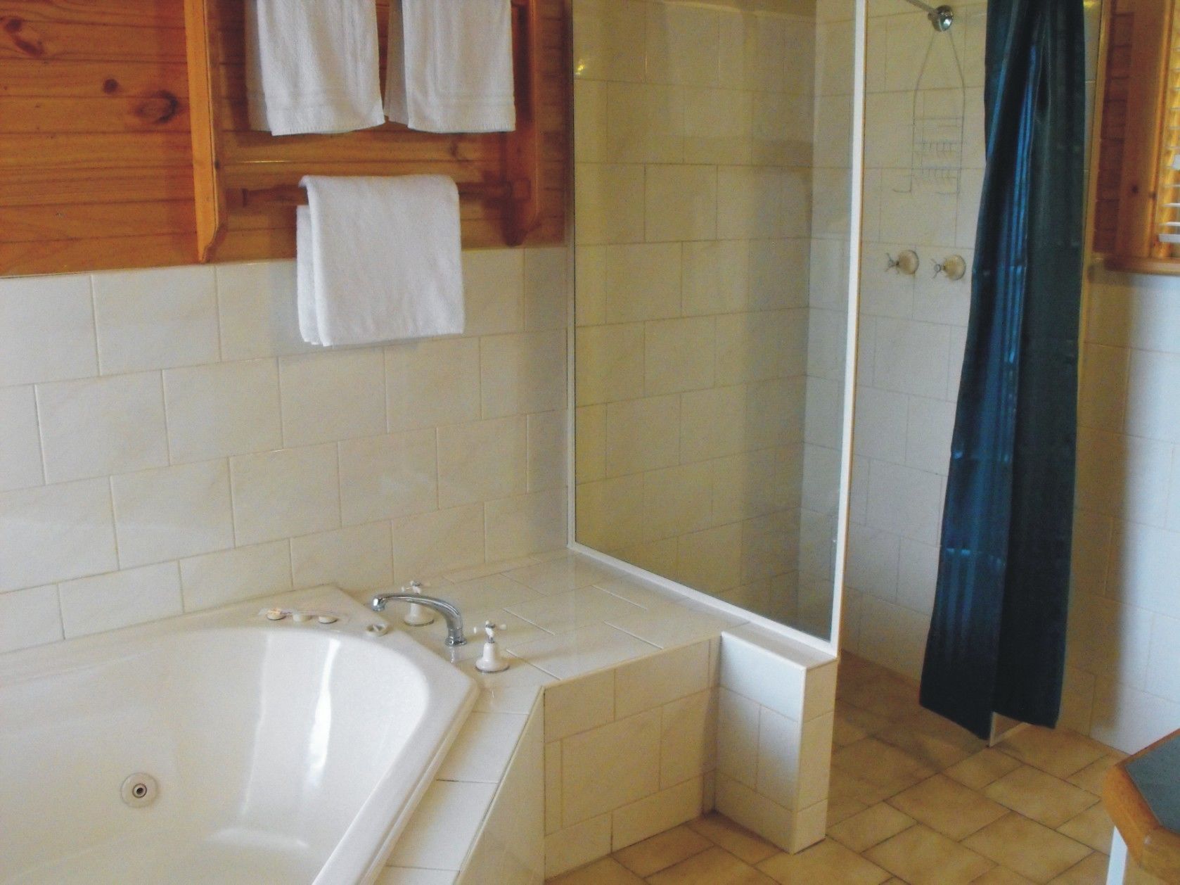 A bathroom with a bathtub, a shower, and a mirror.