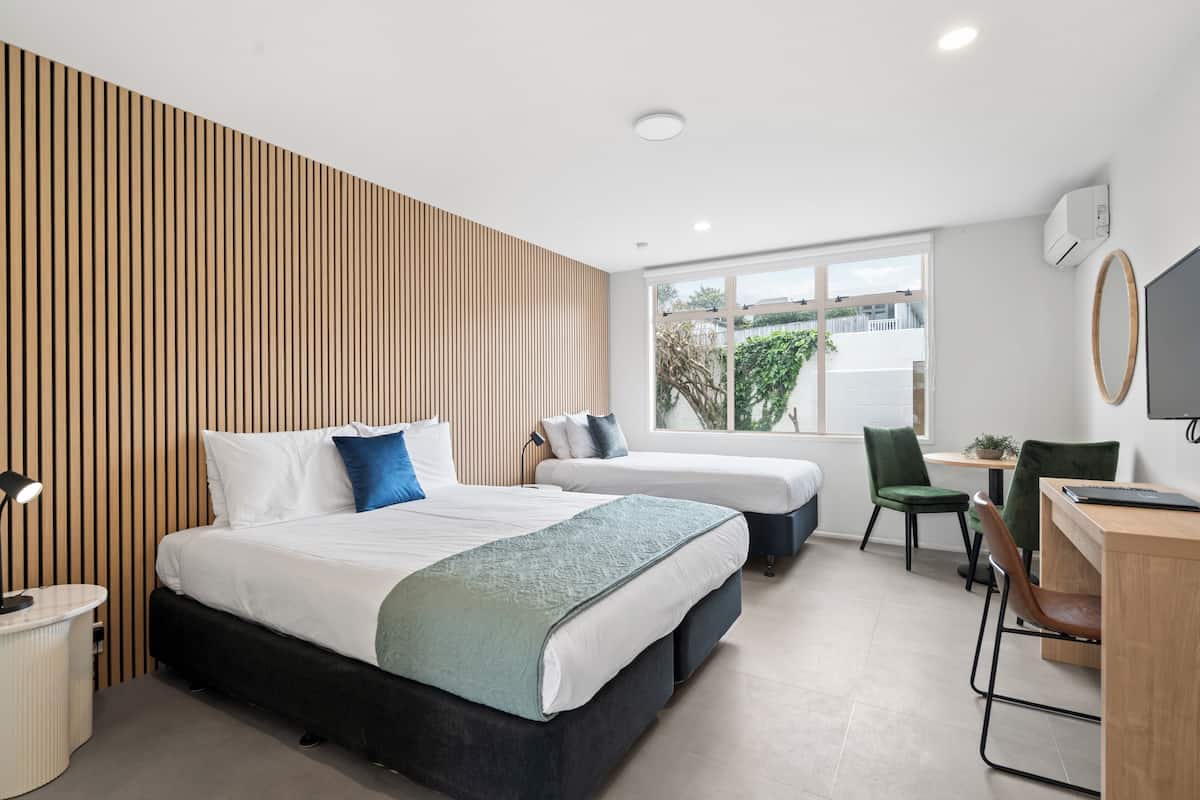 Ein modernes Hotelzimmer mit einem großen Bett, einem Schreibtisch und einem Fenster mit Blick.