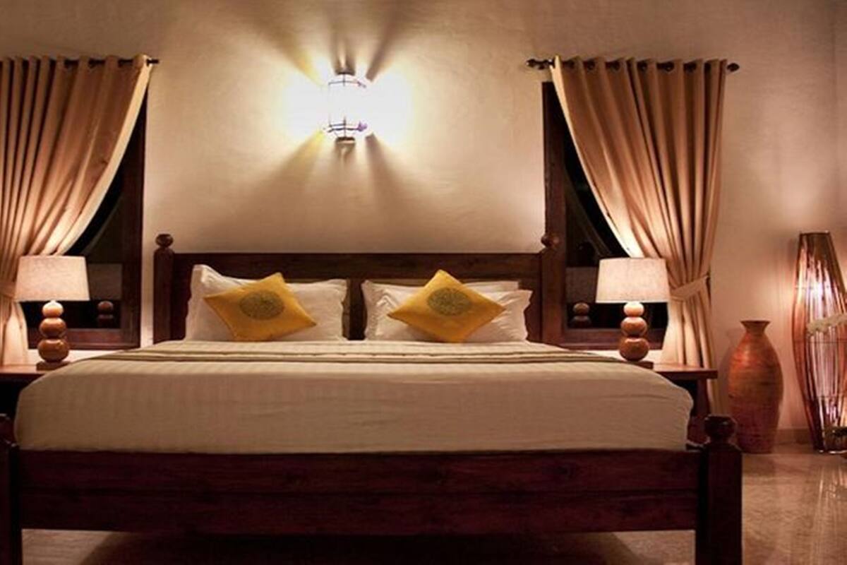 Ein Hotelzimmer mit einem großen Bett, zwei Nachttischen und einer Wandleuchte.