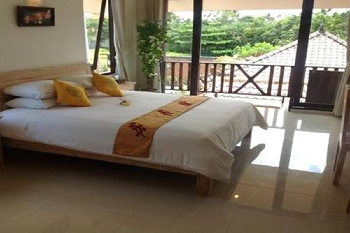 Ein Schlafzimmer mit einem hölzernen Bett, weißer Bettwäsche und einer Zierdecke.