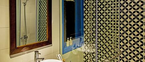 A bathroom with a white sink, a mirror, and a shower with a glass door.