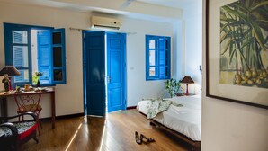 A bedroom with a bed, a desk, a chair, and a ceiling fan. - Maison d'Orient Hotel (Hanoi)