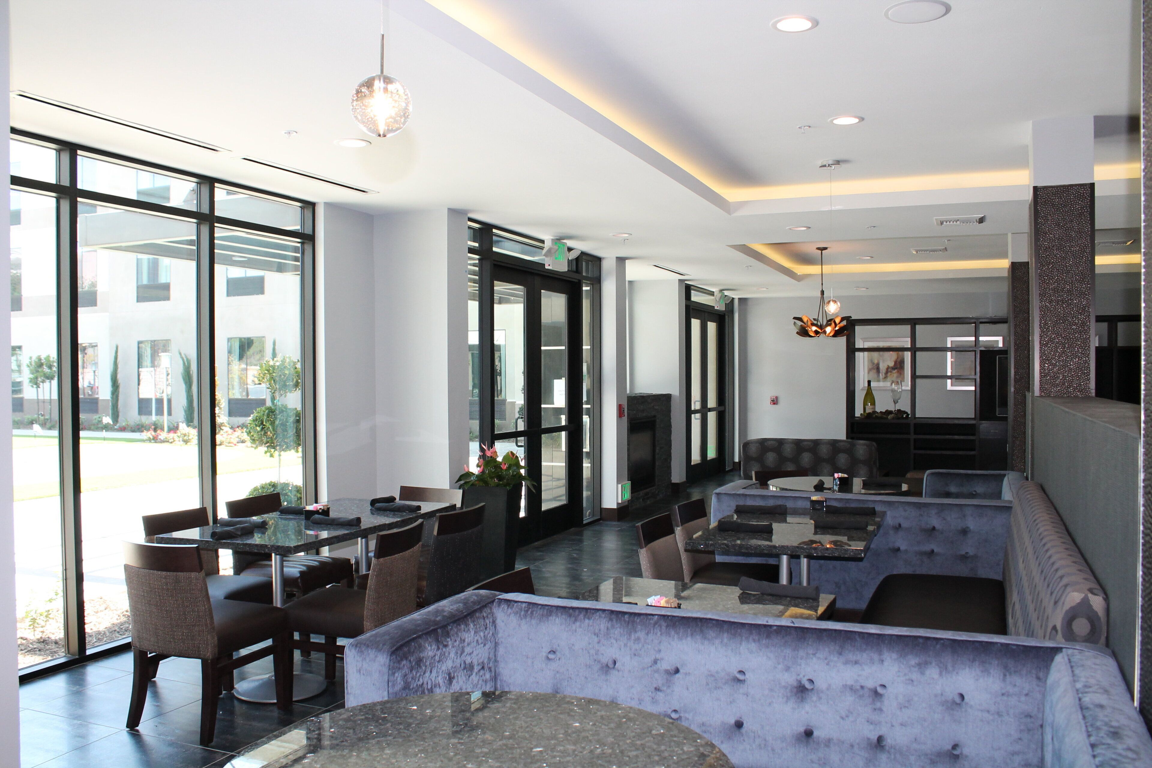 A modern interior with a seating area, tables, and a fireplace.