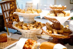 Ein Büfett mit verschiedenen Brotsorten und Gebäck, präsentiert in Korbflexwebenkörben.