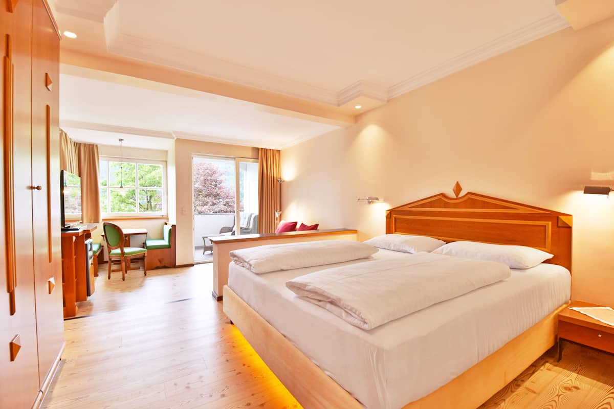 Una habitación de hotel con una cama grande, un escritorio y una silla.