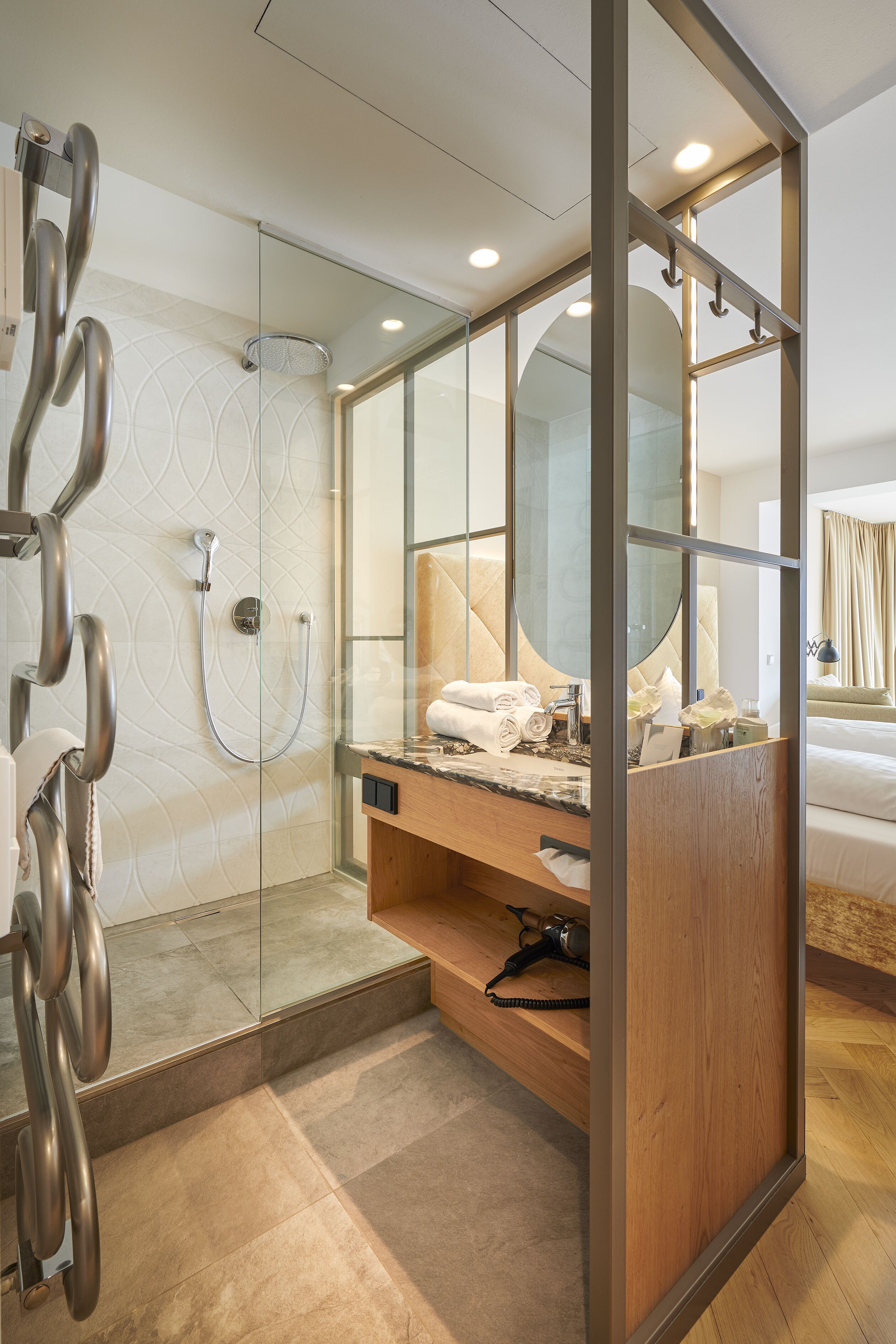 A modern bathroom with a glass shower enclosure, a wooden vanity, and a large mirror.