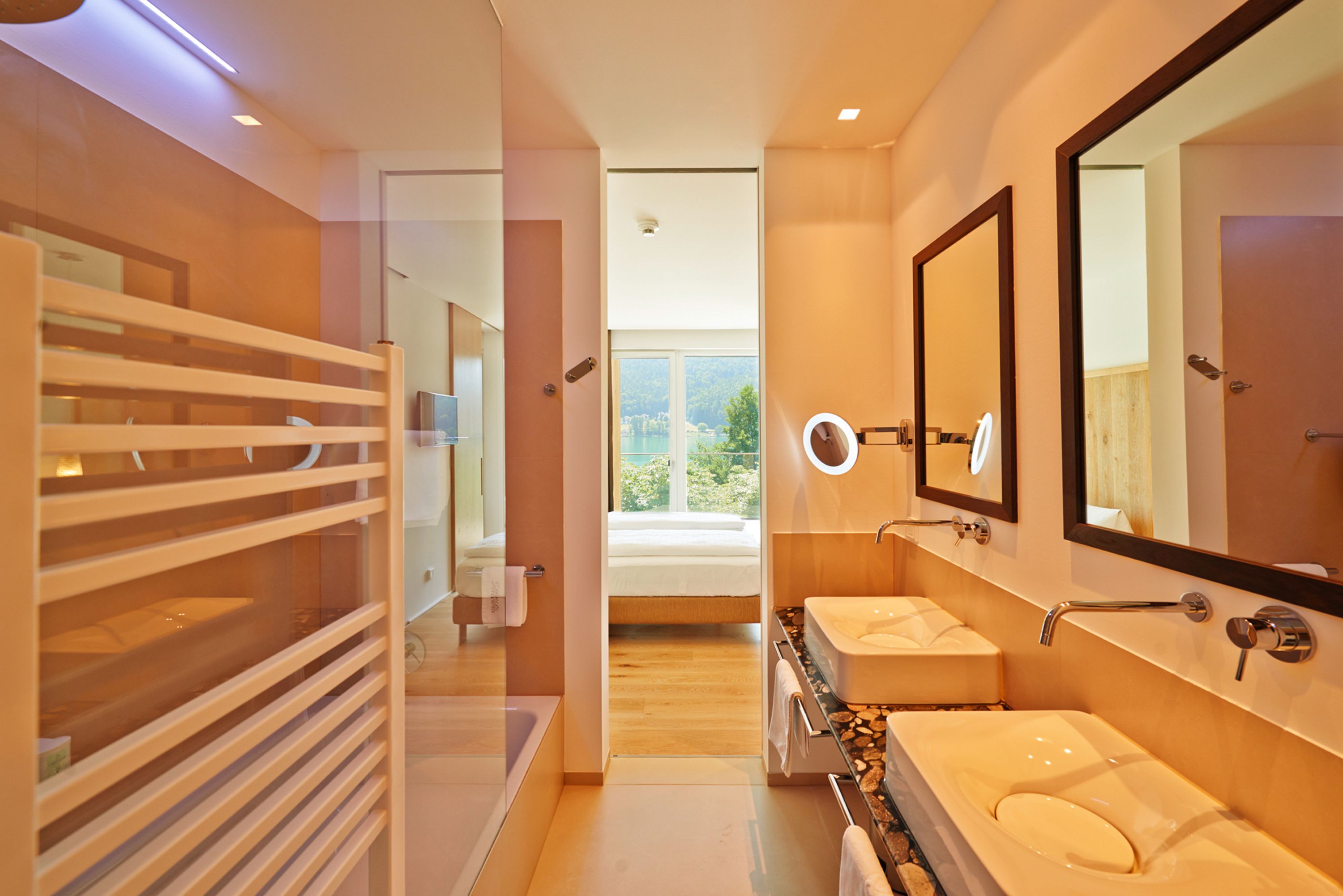 Ein modernes Badezimmer mit barrierefreier Dusche, einem Doppelwaschtisch und einem großen Spiegel.