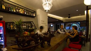 Baarialue, jossa on puinen tiski, koristeellinen kattokruunu ja kyltti, jossa lukee: ”TeVI Restaurant & Bar”.