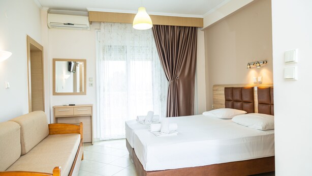 A hotel room with a bed, a sofa, a desk, and a mirror. - Studios Pieria (Dio-Olympos)