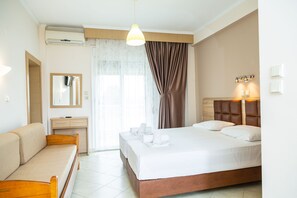 A hotel room with a bed, a sofa, a desk, and a mirror. - Studios Pieria (Dio-Olympos)