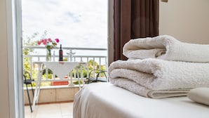 A hotel room with a bed, a balcony with a table and chairs, and a view of the outdoors. - Studios Pieria (Dio-Olympos)