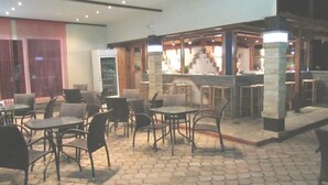 A restaurant with outdoor seating, a bar area, and a large window. - Studios Pieria (Dio-Olympos)