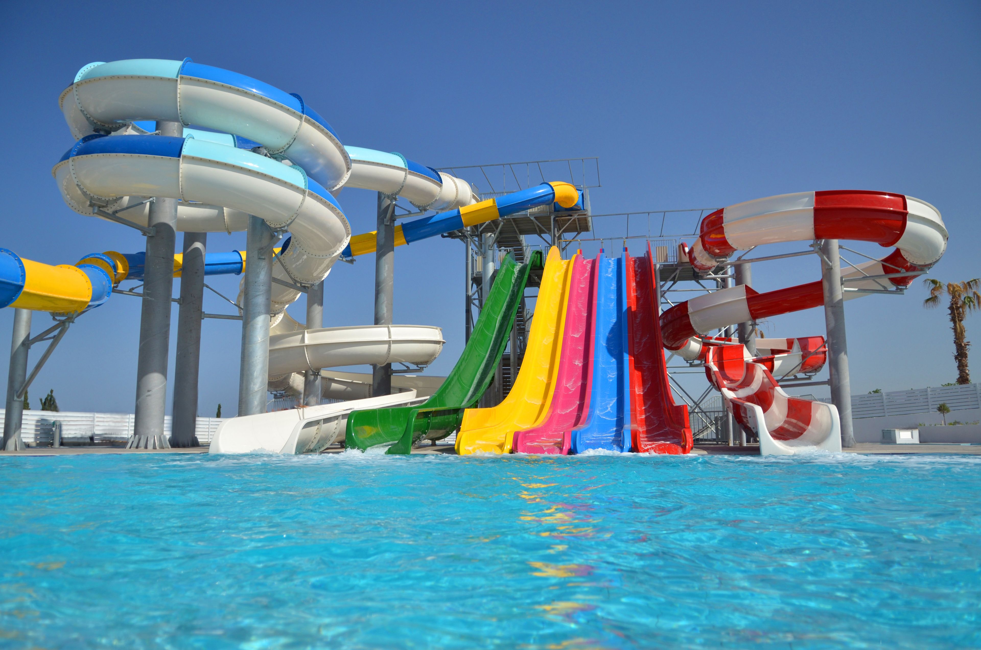 Un parc aquatique doté de nombreuses toboggans de différentes couleurs.