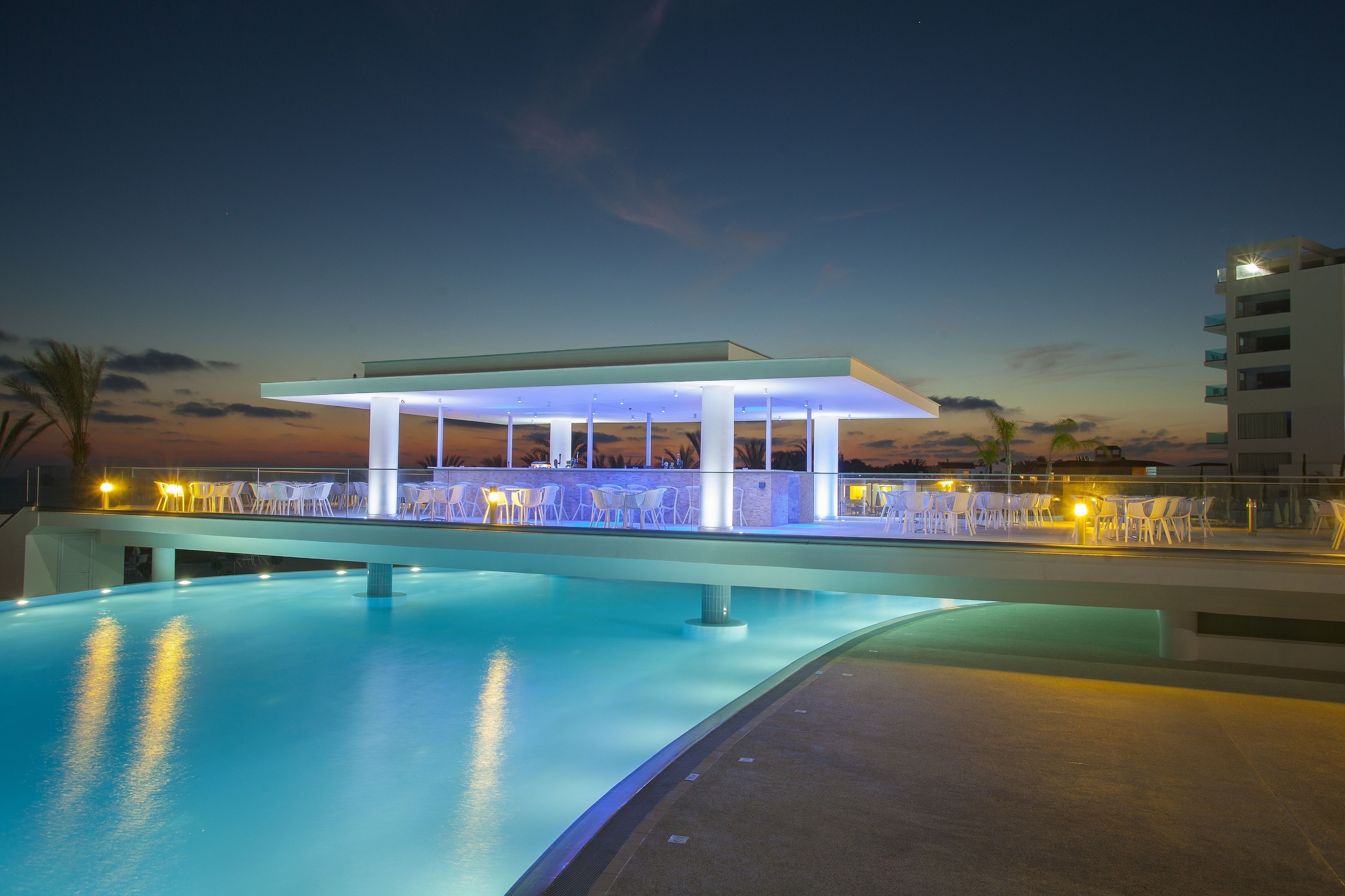 Una zona junto a la piscina con un espacio de descanso cubierto y una piscina.