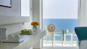 Una cocina moderna con vista al mar, un comedor con mesa y sillas, y un ventanal grande.