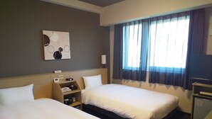 Una habitación de hotel con dos camas, un escritorio, un televisor y una obra de arte colgada en la pared.