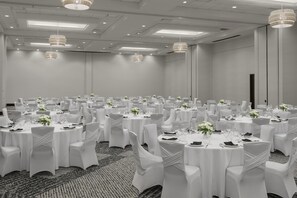 A large conference room with round tables, white chairs, and chandeliers. - Embassy Suites by Hilton Tuscaloosa Alabama Downtown (Tuscaloosa)