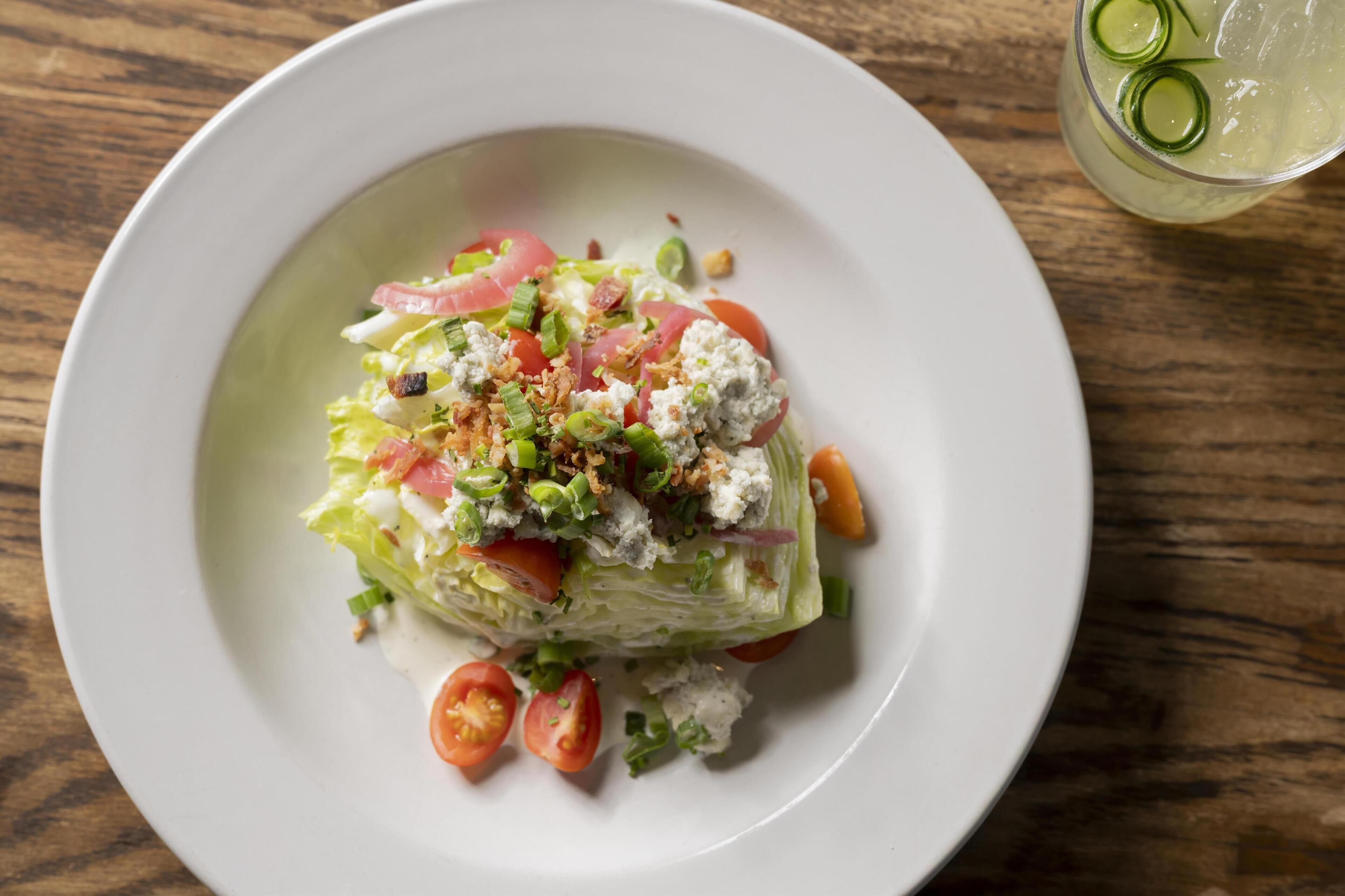 Un plato con ensalada sobre una mesa de madera.