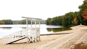 A lifeguard tower at a beach with a sandy shore and a calm lake surrounded by trees. - Hampton Inn Lewiston-Auburn (Lewiston)