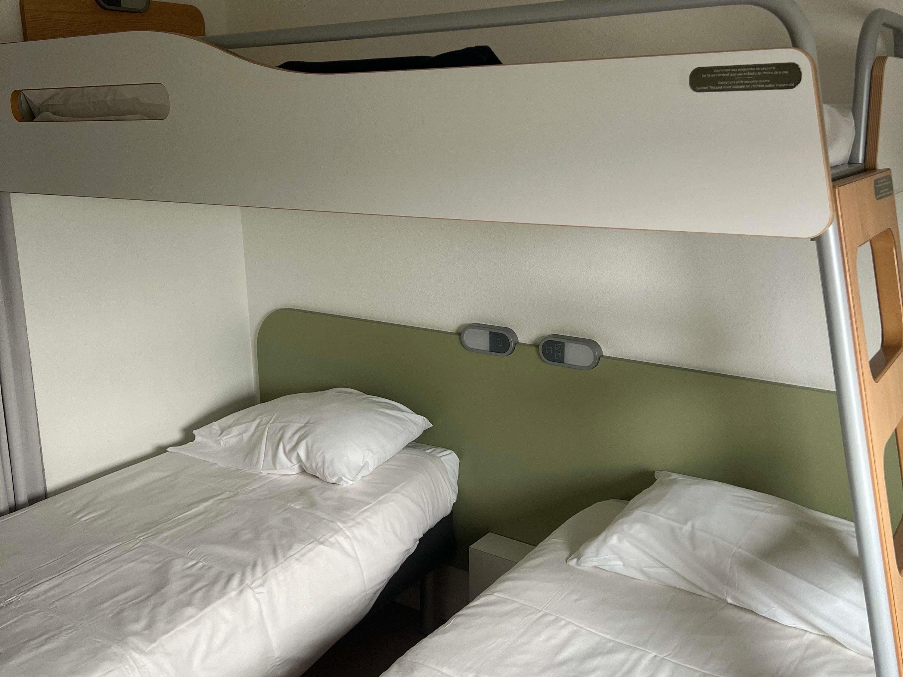 A bunk bed with a headboard and two control panels.