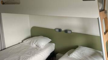 Una cama litera con cabecera y dos paneles de control.