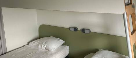 A bunk bed with a headboard and two control panels.