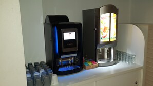 Una máquina de café con pantalla digital y dispensador de bebidas con menú.