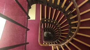 A spiral staircase with a red carpet and yellow accents. - Liberty (Paris)