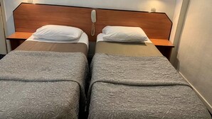 A double room with two beds, each with a wooden headboard and bedside tables. - Liberty (Paris)